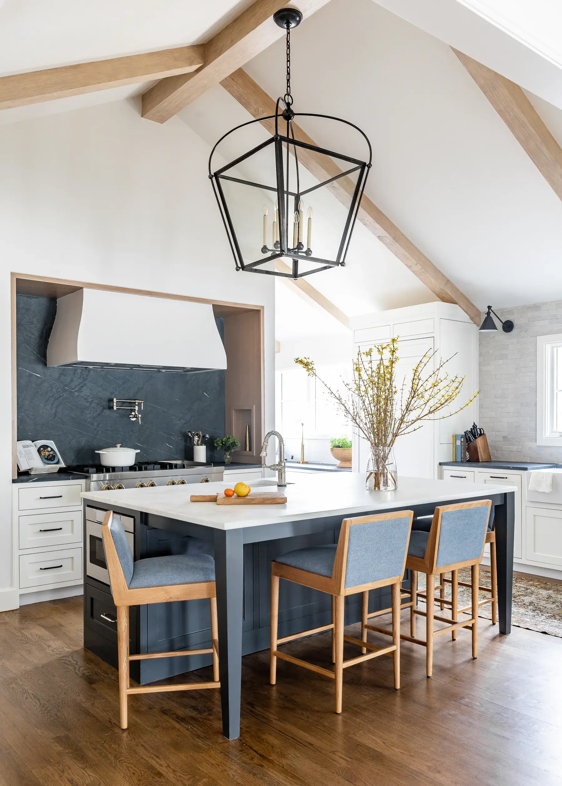Kitchen remodel with rich blue cabinetry, wood accents, and a stone island